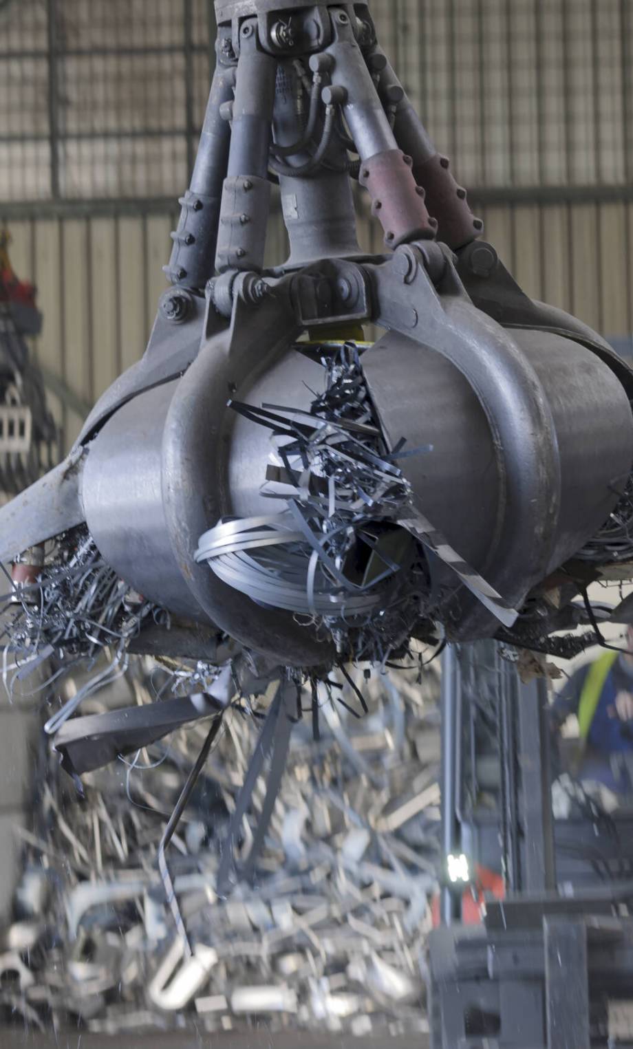 Clamshell grabbing scrap in a scrap metal recycling plant